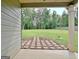 Spacious backyard view from the covered patio, featuring a stone path surrounded by lush green grass and trees at 234 Thyme Leaf Way, Locust Grove, GA 30248