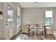 Dining room features a rustic wooden table with white chairs and natural light from windows at 234 Thyme Leaf Way, Locust Grove, GA 30248