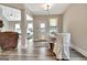 Dining room with a wooden table, white chairs, and lots of natural light that brings brightness at 234 Thyme Leaf Way, Locust Grove, GA 30248