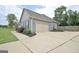Spacious two-car garage and long driveway, complemented by well-maintained landscaping and mature trees at 234 Thyme Leaf Way, Locust Grove, GA 30248