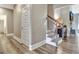 Hallway featuring hardwood floors and neutral paint colors, leading to staircase and living area at 234 Thyme Leaf Way, Locust Grove, GA 30248