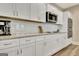 Modern kitchen featuring white cabinets, granite countertops, and stainless steel microwave at 234 Thyme Leaf Way, Locust Grove, GA 30248