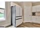 Modern kitchen features a stainless steel refrigerator and sleek white cabinetry for a clean look at 234 Thyme Leaf Way, Locust Grove, GA 30248