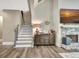 Cozy living room with a stone fireplace, modern decor, and staircase at 234 Thyme Leaf Way, Locust Grove, GA 30248
