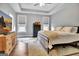 Bright main bedroom featuring a tray ceiling, hardwood floors, and a walk-in closet at 234 Thyme Leaf Way, Locust Grove, GA 30248