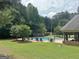 Beautiful outdoor pool area with lounge chairs, umbrellas, and well-maintained landscaping at 234 Thyme Leaf Way, Locust Grove, GA 30248