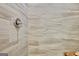 Close-up of shower featuring a silver shower head and marble-look tile at 234 Thyme Leaf Way, Locust Grove, GA 30248