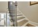 View of the staircase with grey treads, white risers, and black metal balusters at 234 Thyme Leaf Way, Locust Grove, GA 30248