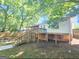 Back of the house with deck, staircase, and mature shade trees at 1150 Goldsmith Rd, Stone Mountain, GA 30083