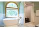 Bathroom with a soaking tub, walk-in shower, large window, and tiled floors at 1655 Stacia Dr, Covington, GA 30016