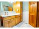 This spacious bathroom includes a large vanity, a standalone storage cabinet, and white tiled walls at 1655 Stacia Dr, Covington, GA 30016