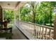 Relaxing front porch with chairs, a glass-topped table, and views of the mature trees at 1655 Stacia Dr, Covington, GA 30016
