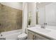 Well-lit bathroom featuring a shower-tub combo with updated tile and a white single sink vanity at 1058 Kirkland Cir, Smyrna, GA 30080