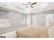 Bedroom featuring tray ceilings, a fan, two large windows, and a comfortable bed at 1058 Kirkland Cir, Smyrna, GA 30080