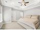 Bright primary bedroom with neutral colored walls, fan, tray ceiling, and carpet at 1058 Kirkland Cir, Smyrna, GA 30080