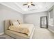 Bedroom with tray ceilings, fan, and a large bed with neutral color linens at 1058 Kirkland Cir, Smyrna, GA 30080