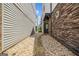Side view of a townhome with a stone facade and pea gravel walkway to a black front door at 1058 Kirkland Cir, Smyrna, GA 30080