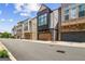 Street view of the townhome, showing attached garage and stacked stone and neutral colored siding at 1058 Kirkland Cir, Smyrna, GA 30080