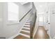 Bright foyer with hardwood floors, stairs with wood and iron railing, white walls, and entry door at 1058 Kirkland Cir, Smyrna, GA 30080