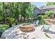 Stone fire pit in backyard with patio, mature trees, and outdoor seating at 350 Ridgemont Dr, Fayetteville, GA 30215