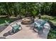 Charming stone fire pit with Adirondack chairs surrounded by lush landscaping at 350 Ridgemont Dr, Fayetteville, GA 30215