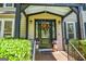 Elegant front entrance with a decorative wreath on the door, potted plants, and stylish exterior lighting at 350 Ridgemont Dr, Fayetteville, GA 30215