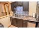 Close-up of the kitchenette with dark cabinetry, granite countertop, and stainless steel accents at 350 Ridgemont Dr, Fayetteville, GA 30215