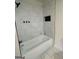 Tiled bathtub and shower with inset storage, tiled walls and floors at 6072 Holiday Blvd, Forest Park, GA 30297