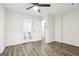 Bright bedroom showcasing wood-look flooring, white walls, ceiling fan, and an attached bathroom at 6072 Holiday Blvd, Forest Park, GA 30297