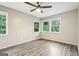 Bedroom featuring wood-look flooring, three windows, and a ceiling fan at 6072 Holiday Blvd, Forest Park, GA 30297