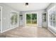 Living room with sleek wood floors, built-in cabinets, and doors leading to the back deck at 6072 Holiday Blvd, Forest Park, GA 30297