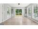 Living room with sleek wood floors, built-in cabinets, and doors leading to the back deck at 6072 Holiday Blvd, Forest Park, GA 30297