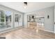 Living room open to kitchen, featuring sleek wood floors and natural light from surrounding windows at 6072 Holiday Blvd, Forest Park, GA 30297