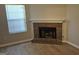 Corner shot of the living room showing the wood flooring, a brick fireplace, and a window with blinds at 6120 Raleigh Oaks Ct, Lithonia, GA 30058