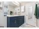 Modern bathroom features double sinks, blue vanity with large mirror, and marble tile floor at 1108 The By Way, Mcdonough, GA 30252
