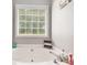 Bright bathroom featuring a pristine white bathtub beneath a window with wood blinds at 1108 The By Way, Mcdonough, GA 30252