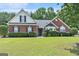 Charming red brick home with lush green lawn and manicured hedges under a blue sky at 1108 The By Way, Mcdonough, GA 30252