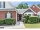 Close up exterior view of a red brick home with manicured hedges at 1108 The By Way, Mcdonough, GA 30252