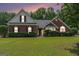 Charming red brick home with lush green lawn and manicured hedges at twilight at 1108 The By Way, Mcdonough, GA 30252