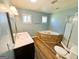 Bright bathroom features a walk-in shower, vanity, and a stone-trimmed jetted tub at 36 Reese St, Grantville, GA 30220