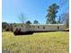 Backyard view of home displaying a metal roof, well maintained lawn, and exterior doors at 36 Reese St, Grantville, GA 30220