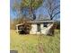 Outdoor shed features an entry door, adjacent parking, and natural yard space at 36 Reese St, Grantville, GA 30220