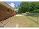 Fenced backyard with brick home, and lush greenery at 416 S Carroll Rd, Villa Rica, GA 30180