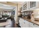 Wet bar area with stone countertops, a wine rack, and storage cabinets, leading to the living room at 750 Highview Ct, Woodstock, GA 30189
