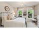 Cozy bedroom with an iron bed frame, a round mirror, and natural light from the windows at 750 Highview Ct, Woodstock, GA 30189