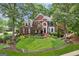 Daytime view of a red brick home with manicured landscaping, dark shutters, and a classic design at 750 Highview Ct, Woodstock, GA 30189