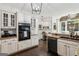 Well-appointed kitchen featuring granite countertops, sleek black appliances, and white cabinets at 750 Highview Ct, Woodstock, GA 30189