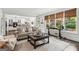 Bright living room with large windows, a cozy couch, and views into the kitchen and out to the yard at 750 Highview Ct, Woodstock, GA 30189
