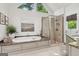 Luxurious bathroom with a soaking tub, glass-enclosed shower, and bright natural light at 750 Highview Ct, Woodstock, GA 30189