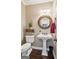 Charming powder room featuring a pedestal sink, decorative mirror, and elegant finishes at 750 Highview Ct, Woodstock, GA 30189